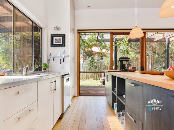 Modern kitchen with natural light, featuring sleek cabinetry and direct access to a spacious outdoor area.