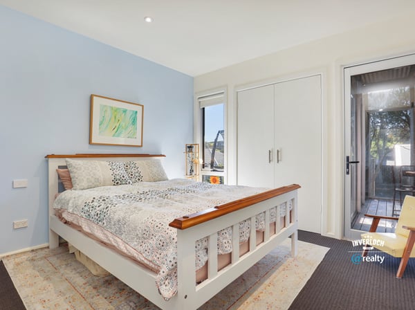 Bright bedroom featuring large windows, offering a peaceful atmosphere and easy access to outdoor living space.