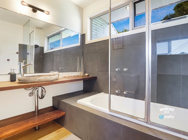 Modern bathroom featuring a sleek vanity, luxurious soaking tub, and large glass shower for ultimate comfort.