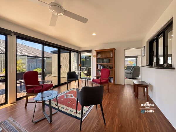 Bright, inviting sunroom featuring large windows, ideal for relaxation or entertaining in a cozy atmosphere.