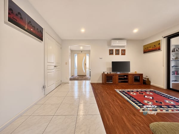 Spacious living area features tile and wood flooring, providing a warm and inviting atmosphere.