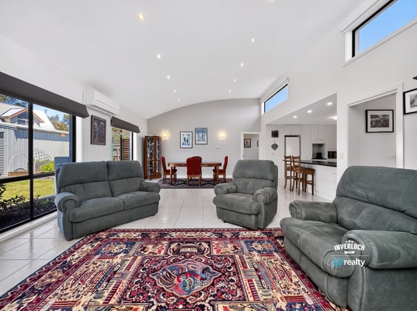 Spacious living area featuring large windows, comfortable seating, and an inviting dining space.