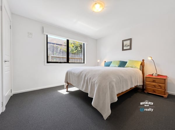 Bright and inviting bedroom with natural light, featuring a comfortable bed and ample closet space.