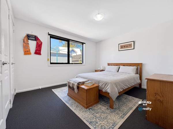 Spacious bedroom featuring ample natural light, modern furnishings, and a cozy atmosphere ideal for relaxation.