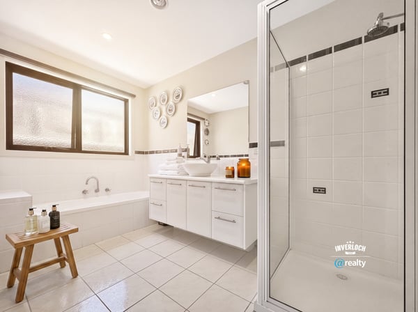 Bright and spacious bathroom featuring a soaking tub, modern shower, and ample storage for comfort and convenience.