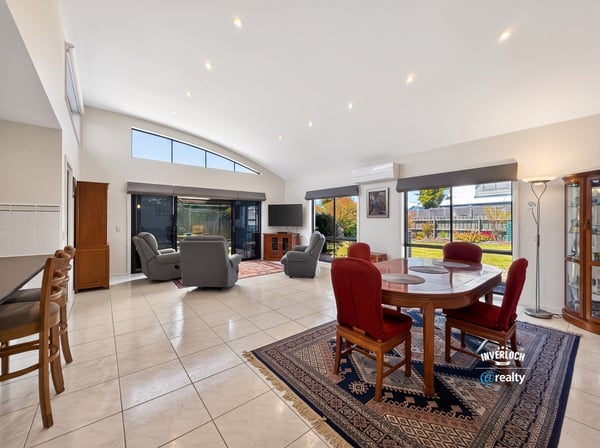 Bright and spacious living area featuring large windows, comfortable seating, and a seamless outdoor transition.