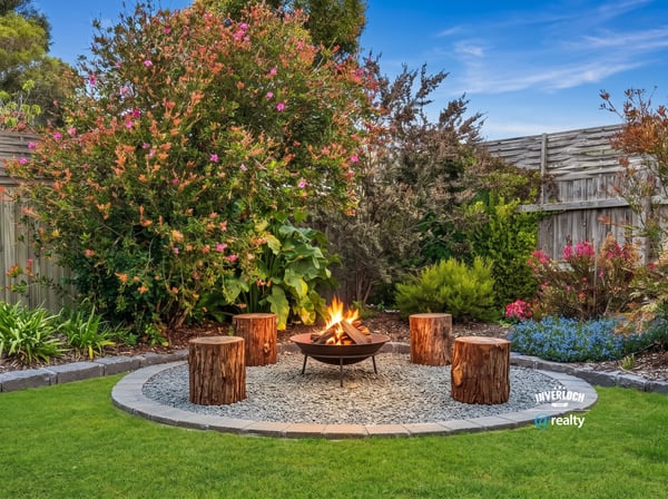 Discover a cozy outdoor oasis featuring a fire pit surrounded by lush landscaping and vibrant flowers.