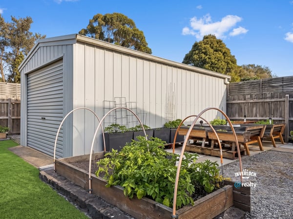 This property features a spacious backyard with a structured shed and thriving garden beds for enthusiasts.