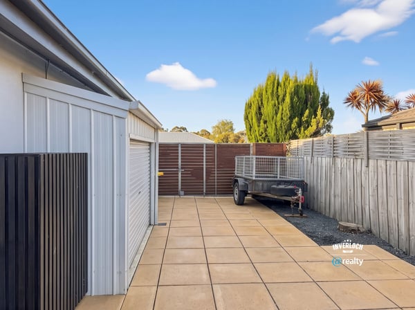 Spacious outdoor area featuring paved parking, perfect for vehicles or recreational equipment, with secure fencing.