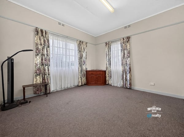 Spacious room featuring large windows, abundant natural light, and versatile flooring for various designs.