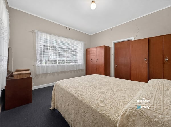 Bright and spacious bedroom featuring built-in wardrobes and ample natural light from large windows.