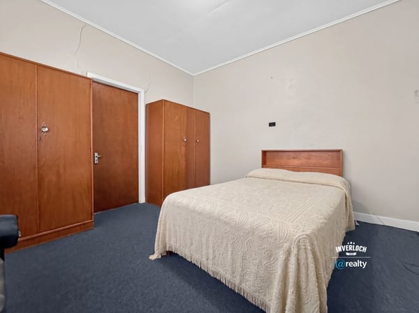Spacious bedroom featuring a queen-size bed and built-in wardrobes, perfect for personalizing your space.