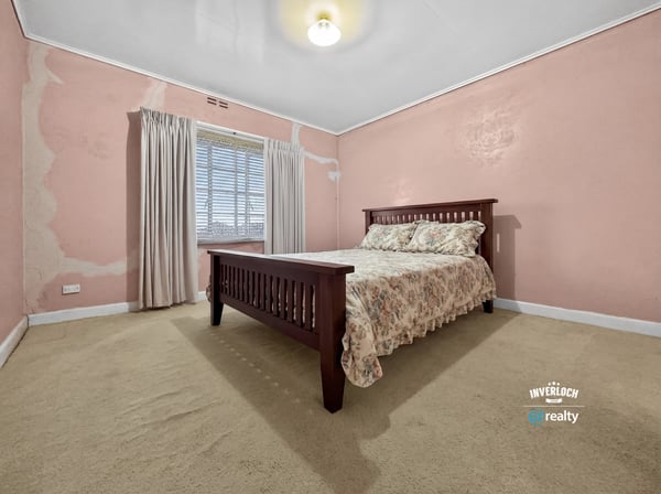 Spacious bedroom featuring natural light, ample storage, and unique wall textures ready for personalization.