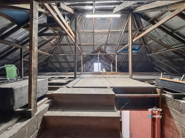 Spacious attic with exposed beams, offering limitless potential for customization or creative use.