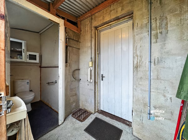 Functional entryway featuring a convenient bathroom and access to additional storage options.