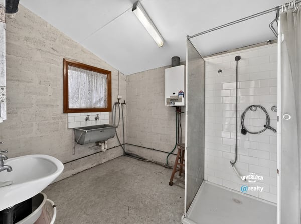 Spacious bathroom featuring a modern shower, practical sink area, and ample natural light.