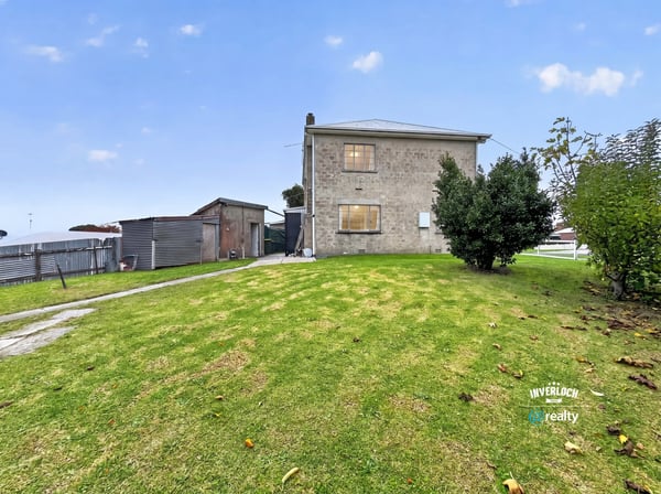 Spacious lot features a two-story home and versatile outbuilding, perfect for renovation or investment opportunities.
