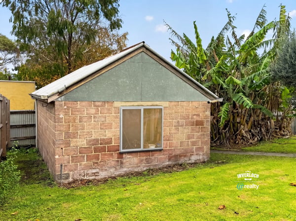 This property offers a unique renovation opportunity amid a spacious backyard surrounded by lush greenery.
