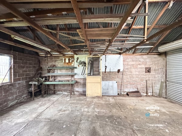 Spacious workshop with ample storage, ideal for projects or hobbies, featuring sturdy structures and natural light.