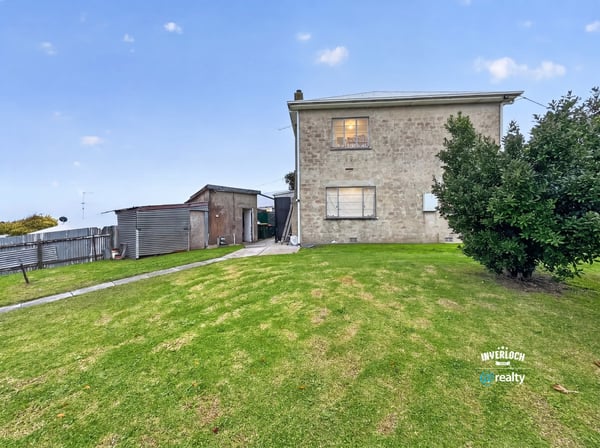 Spacious two-story home on a generous lot, featuring ample outdoor space and a detached shed.