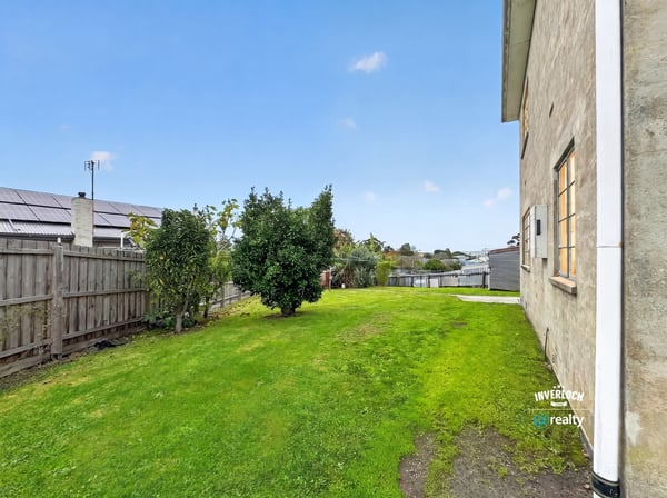 Spacious, grassy side yard offers potential for landscaping or outdoor activities, enhancing the property's appeal.