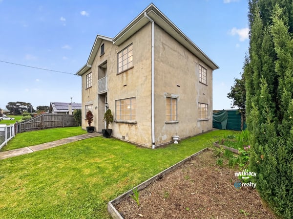 Spacious two-story home featuring a large yard and multiple windows for ample natural light.