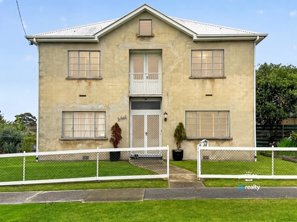 Spacious two-story residence featuring distinct architecture and ample outdoor space for relaxation and activities.