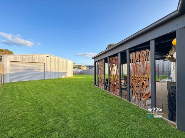 Spacious backyard featuring distinctive decor and a large garage, perfect for outdoor gatherings and hobbies.