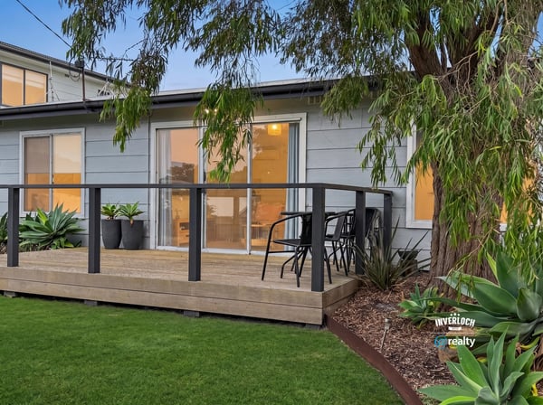 This property features a spacious deck surrounded by lush landscaping, perfect for outdoor relaxation and entertaining.