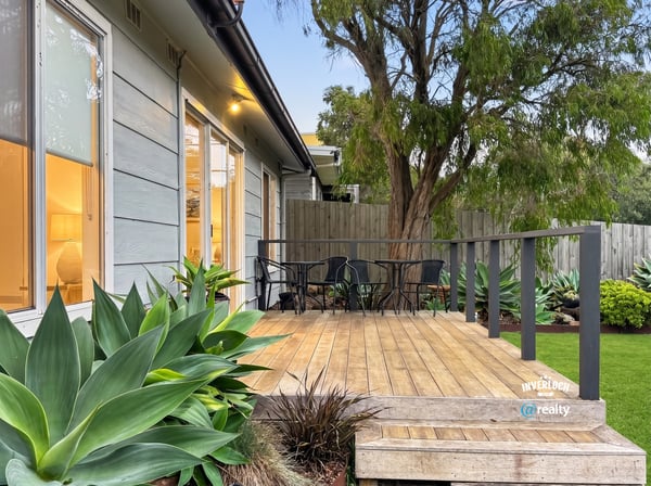 Discover a welcoming outdoor space featuring a spacious deck and lush greenery, perfect for relaxation.
