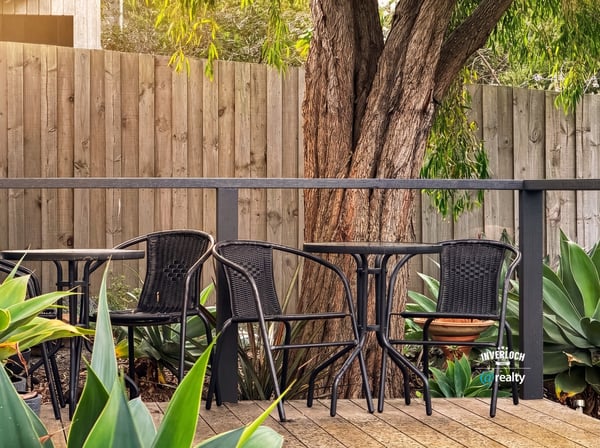 This inviting outdoor space features comfortable seating surrounded by lush greenery, perfect for relaxation or gatherings.