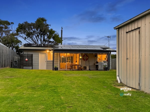 This inviting home features spacious green yard, modern amenities, and a cozy outdoor living area.