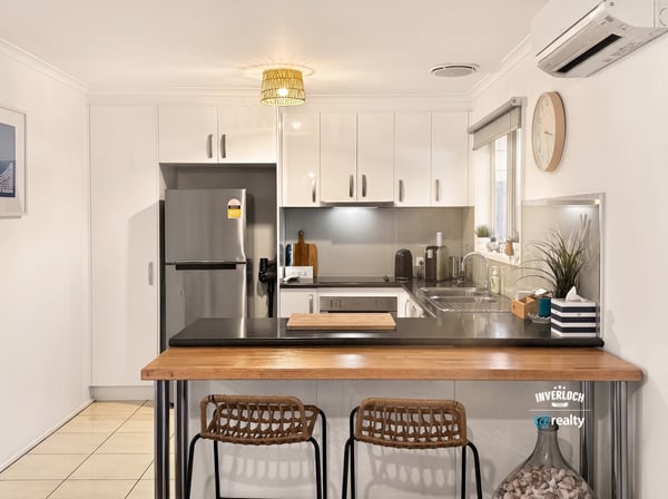 Bright kitchen featuring modern appliances, sleek cabinetry, and a cozy breakfast bar for casual dining.