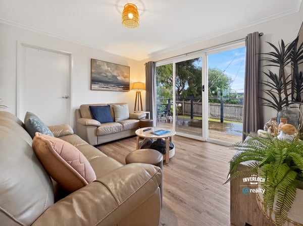 Bright and inviting living space featuring large windows, a cozy atmosphere, and easy outdoor access.