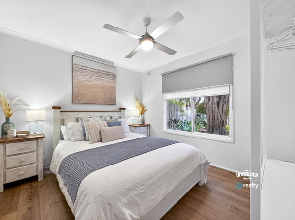 Bright, airy bedroom featuring natural light, modern decor, and a view of lush greenery outside.