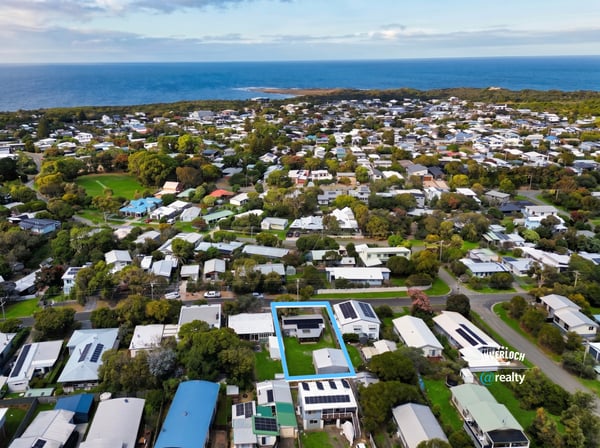 Discover a prime coastal property surrounded by lush greenery and modern homes, just steps from the shoreline.