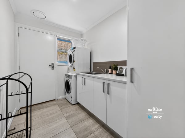 Bright and functional laundry area featuring modern appliances and practical storage solutions to enhance convenience.