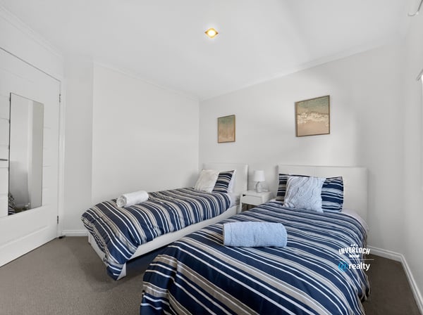 Bright and inviting twin bedroom featuring modern decor and comfortable furnishings for a relaxing stay.