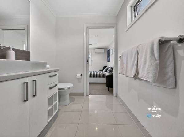 Modern bathroom featuring sleek cabinetry and contemporary finishes, seamlessly connecting to a cozy living area.