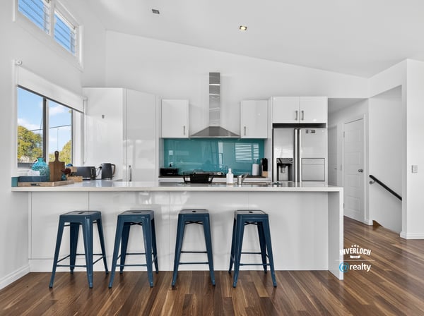 Modern kitchen featuring a striking turquoise backsplash, sleek cabinetry, and ample counter space for entertaining.