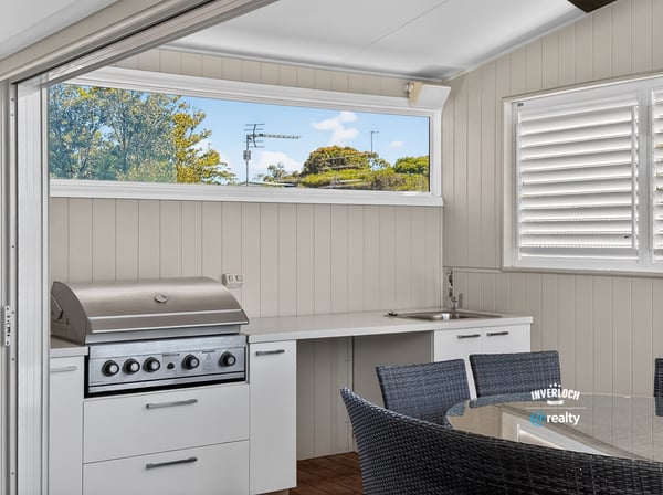This outdoor entertaining space features a built-in grill and modern kitchen perfect for gatherings.
