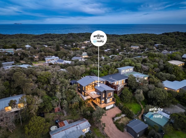 This coastal home offers breathtaking ocean views and modern architecture, nestled among lush greenery.