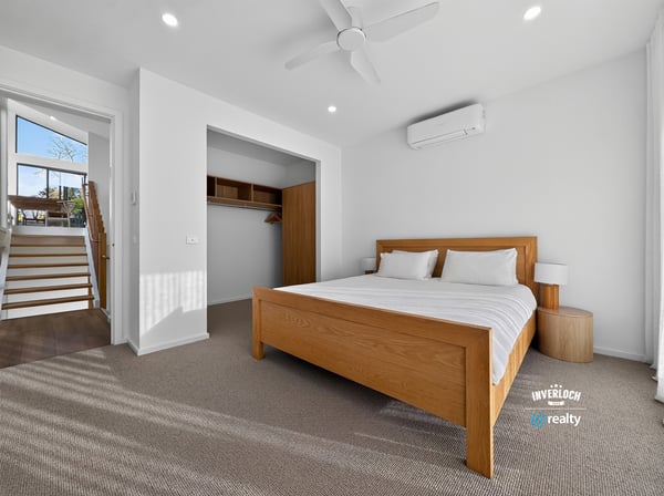Bright and airy bedroom featuring a spacious layout, modern air conditioning, and abundant natural light.