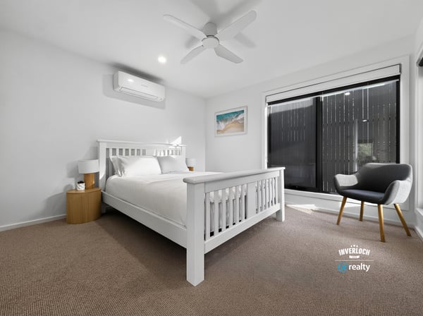 Bright and airy bedroom featuring large windows, modern furnishings, and a cozy atmosphere for relaxation.