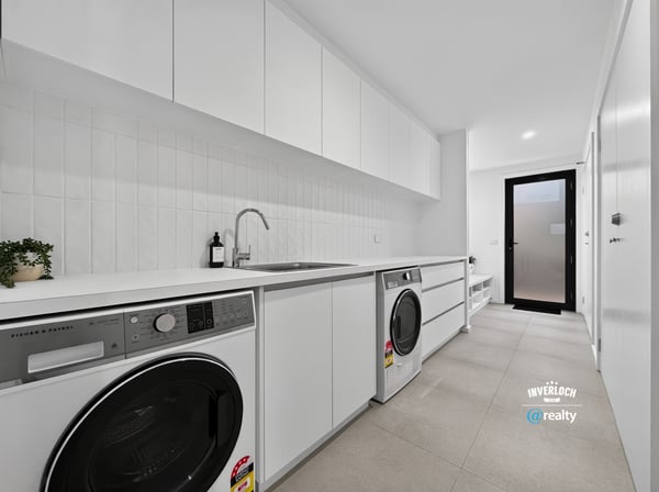 Modern laundry space featuring sleek cabinetry, high-efficiency appliances, and ample storage for convenience.