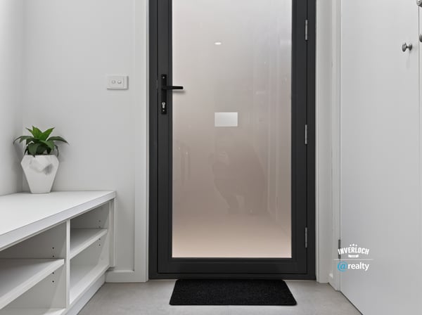 Modern entryway featuring a sleek door and minimalistic design, perfect for welcoming guests.