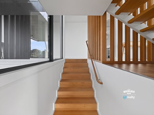 Modern staircase featuring sleek lines and natural light, seamlessly connecting spaces in a contemporary home.