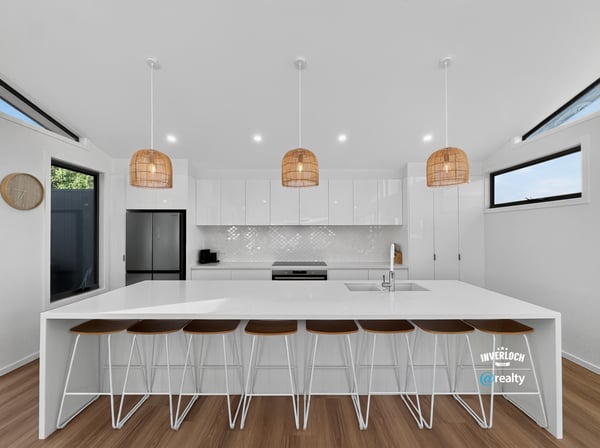 Bright and airy kitchen featuring modern finishes, ample counter space, and inviting seating for gatherings.