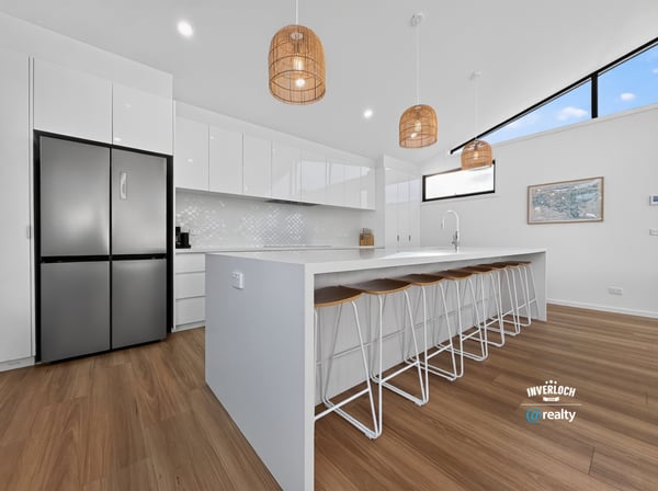 Modern kitchen featuring sleek cabinetry, a spacious island, natural light, and contemporary pendant lighting.
