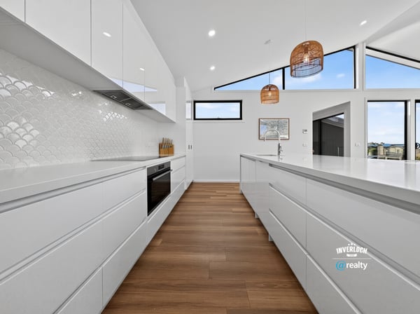Bright and spacious kitchen featuring modern cabinetry, vast countertops, and stunning views through large windows.